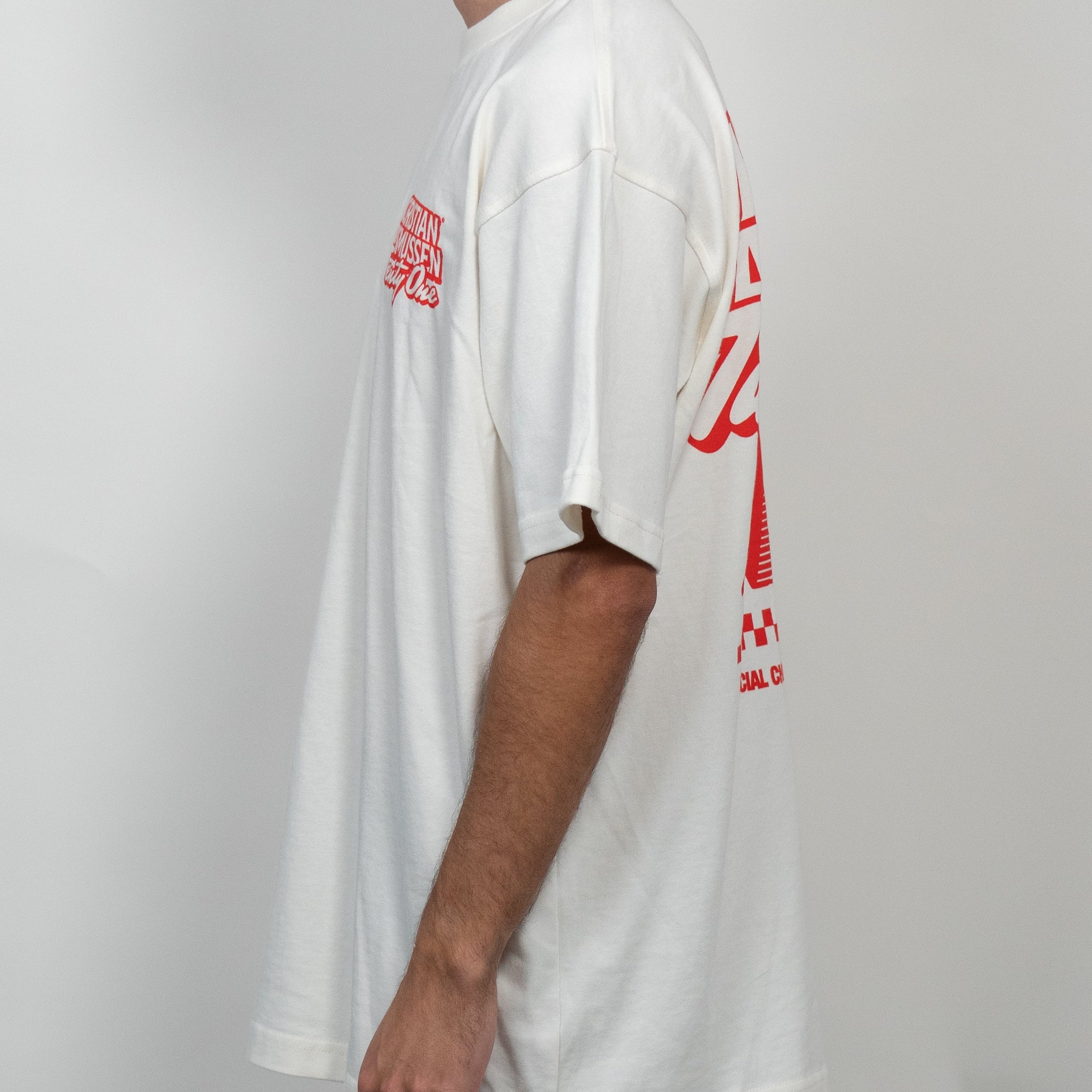 Person wearing a white t-shirt with red graphics on a plain background