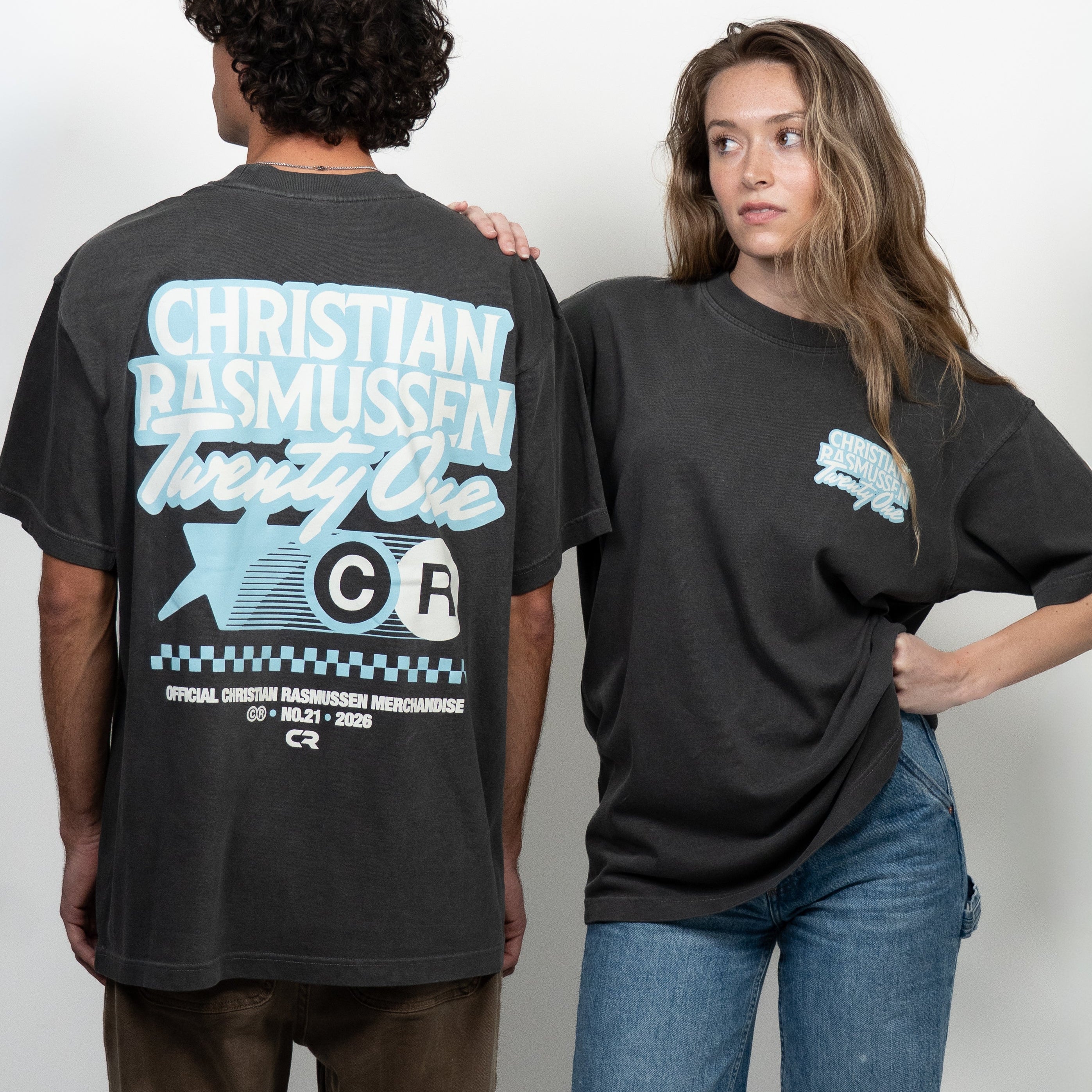 Two people wearing black t-shirts with visible branding against a white background