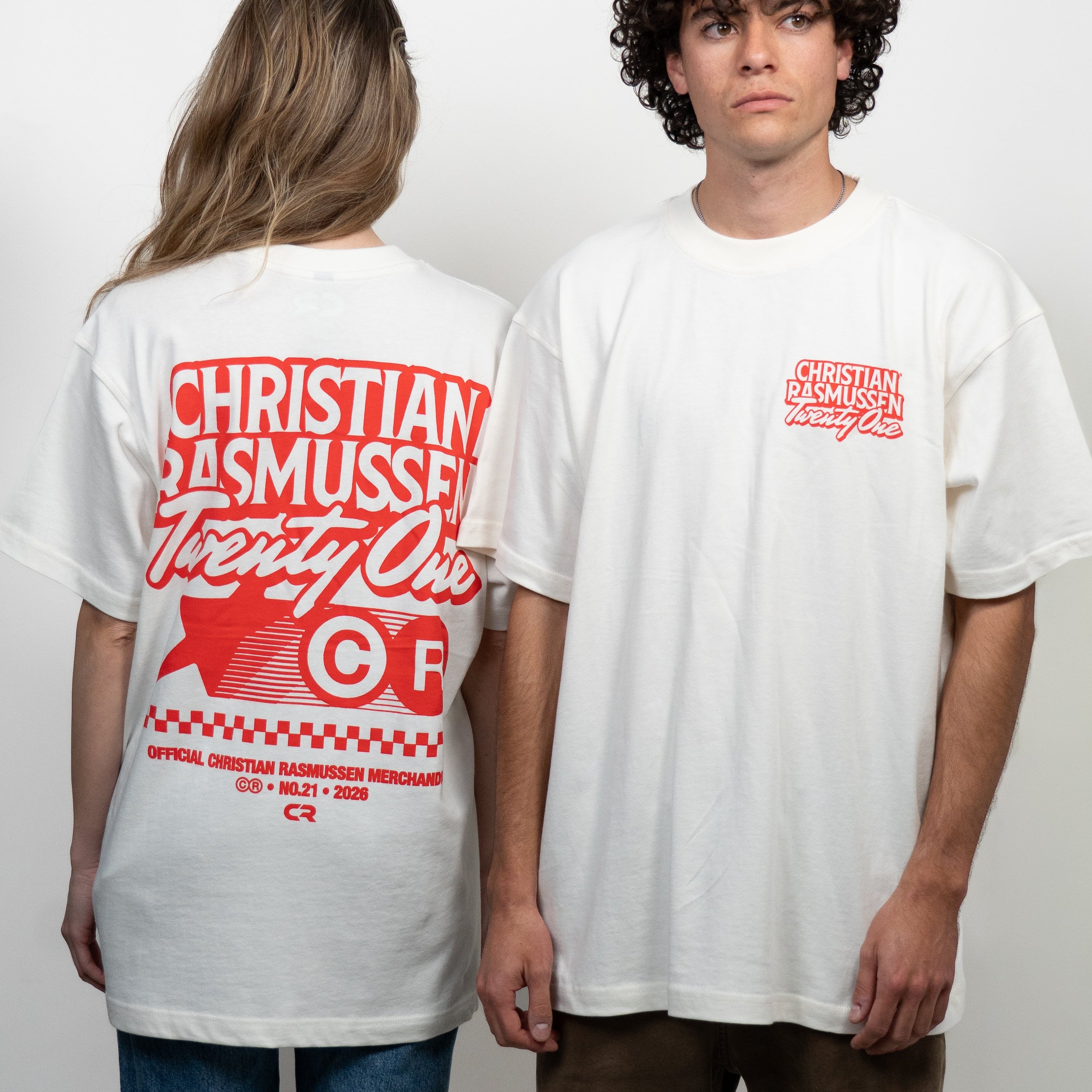 Two people wearing white t-shirts with red text and graphics on a plain background