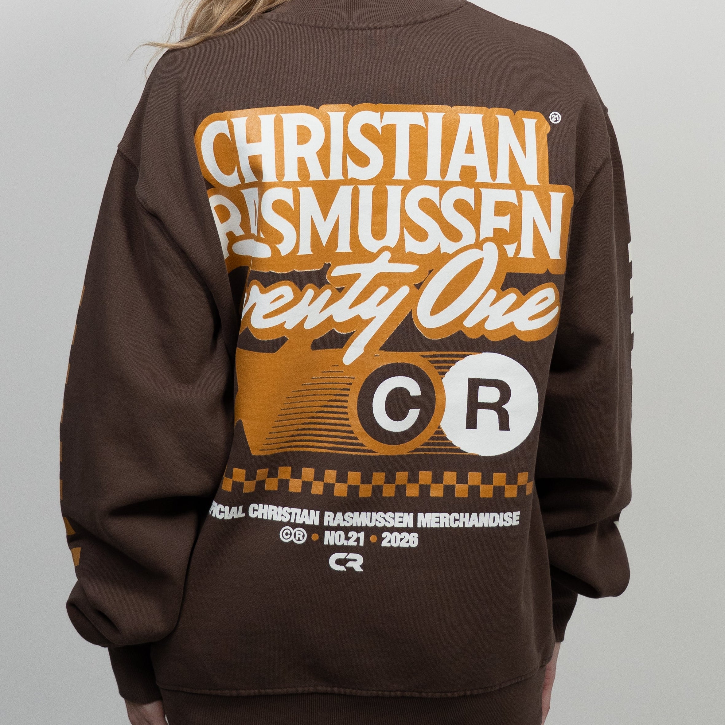 Person wearing a brown sweatshirt with 'Christian Rasmussen' branding on the back.