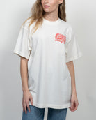 Woman wearing a white t-shirt with red text on a plain background