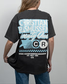 Person wearing a black t-shirt with branding on the back against a gray background