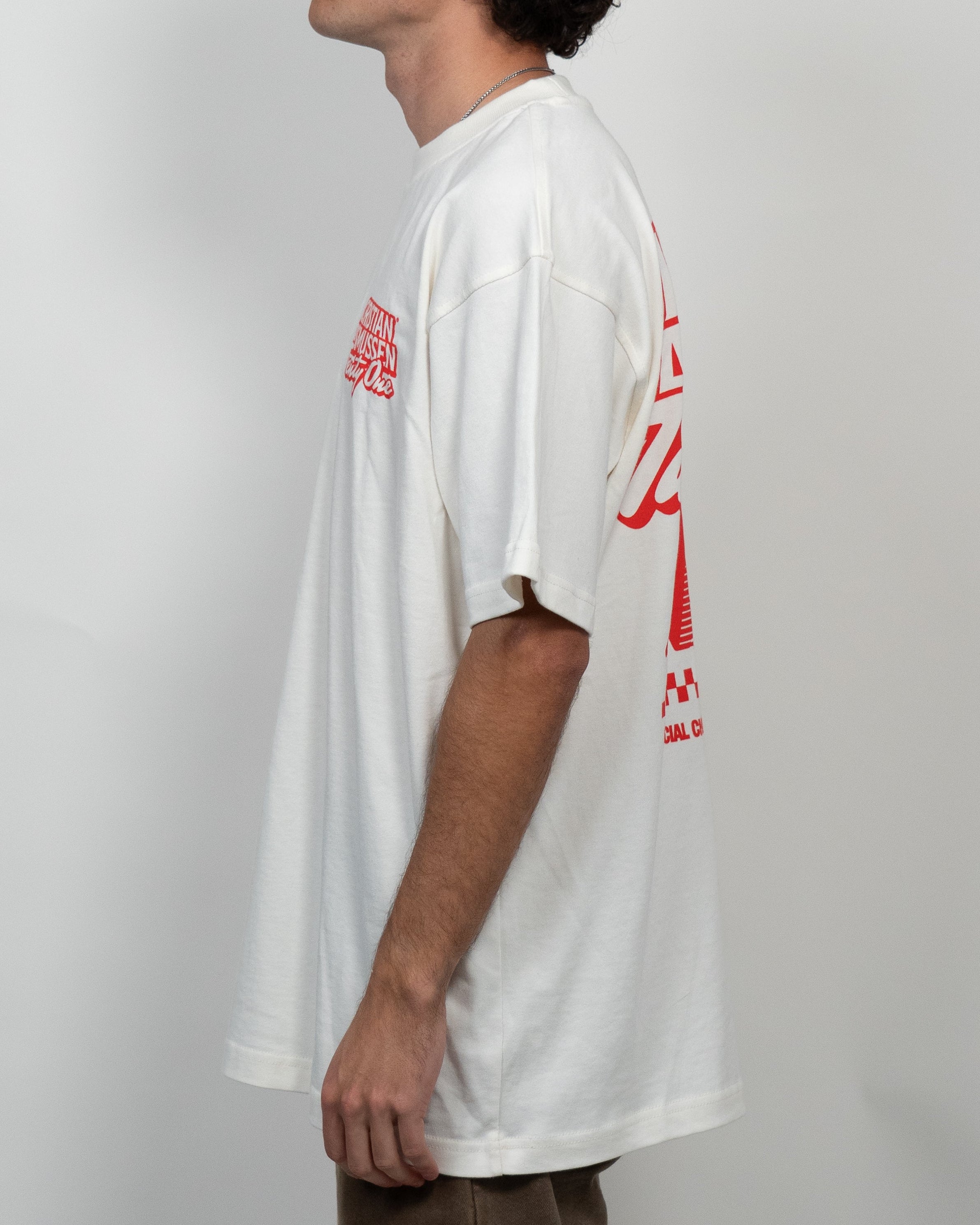 Person wearing a white t-shirt with red graphics on a plain background