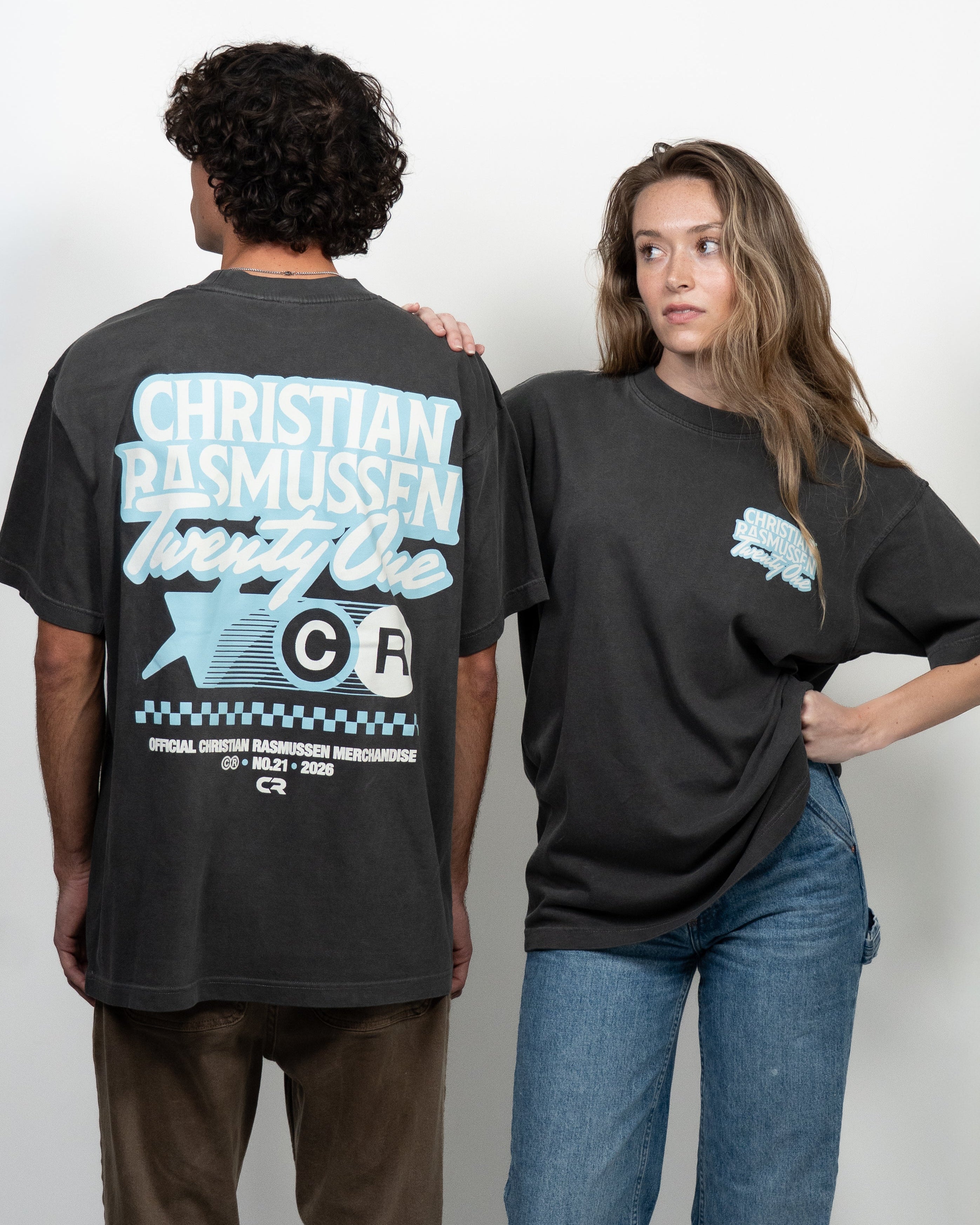 Two people wearing black t-shirts with visible branding against a white background