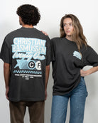 Two people wearing black t-shirts with visible branding against a white background