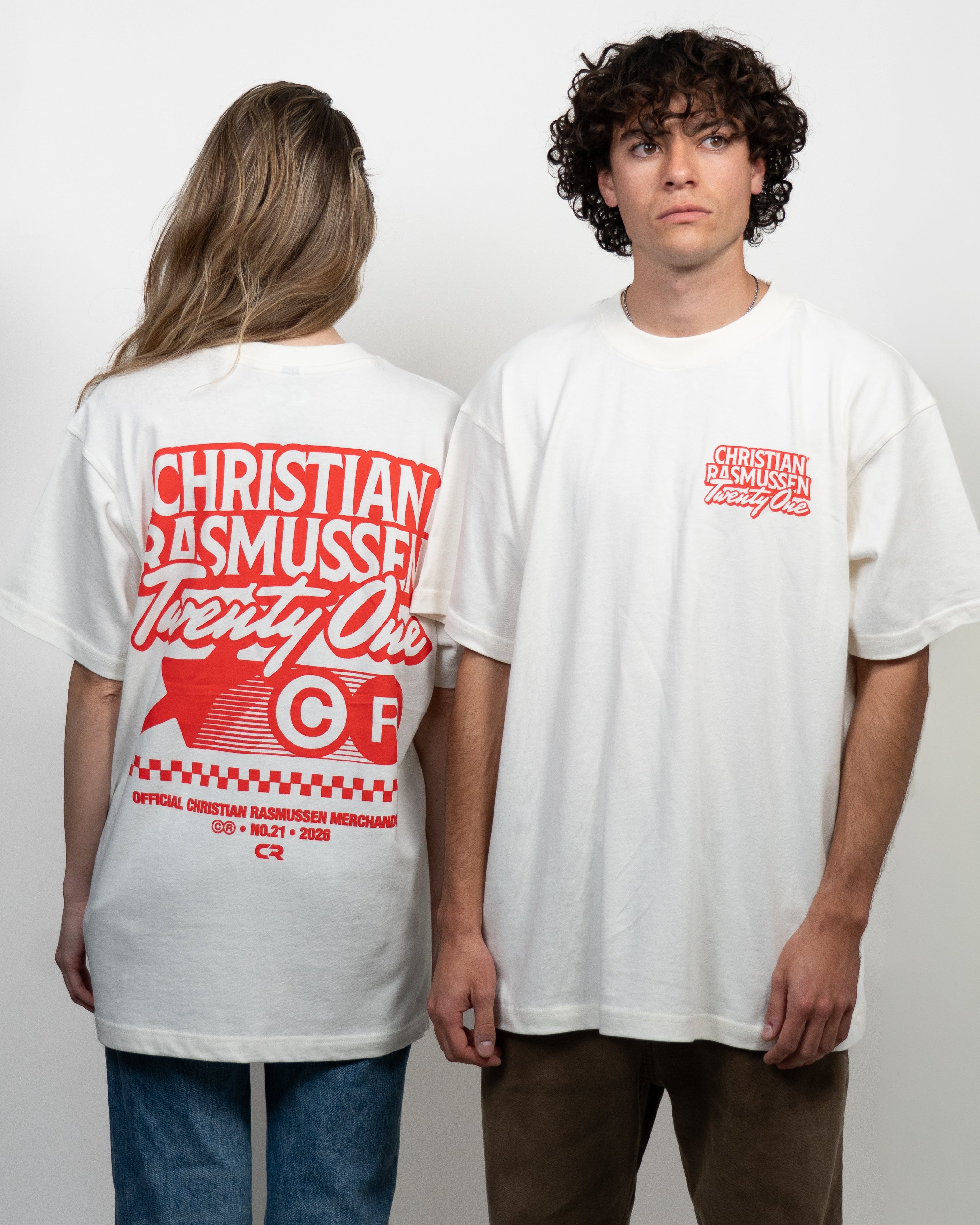 Two people wearing white t-shirts with red text and graphics on a plain background