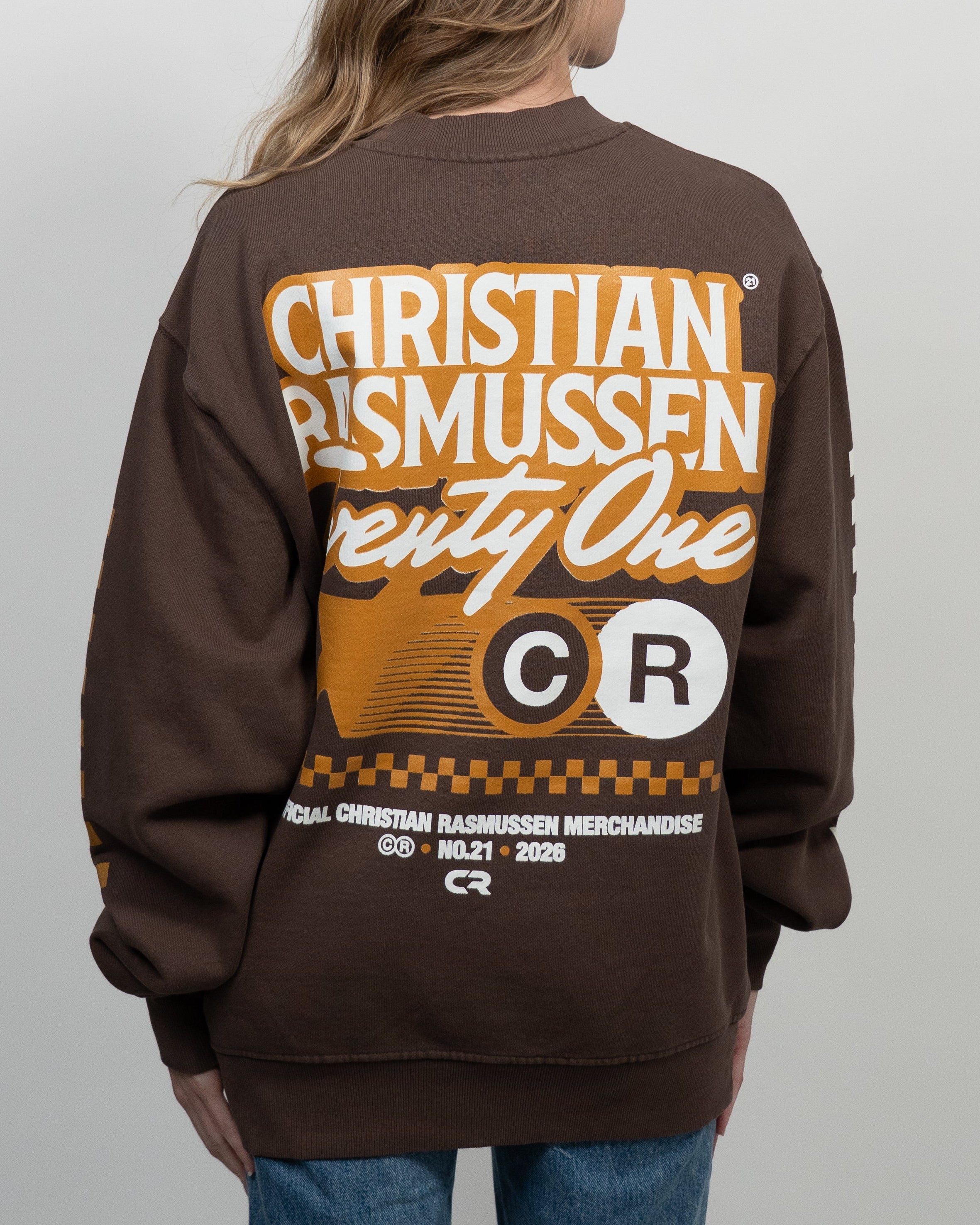 Person wearing a brown sweatshirt with 'Christian Rasmussen' branding on the back.