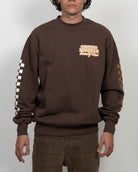 Person wearing a brown sweatshirt with visible branding on a white background