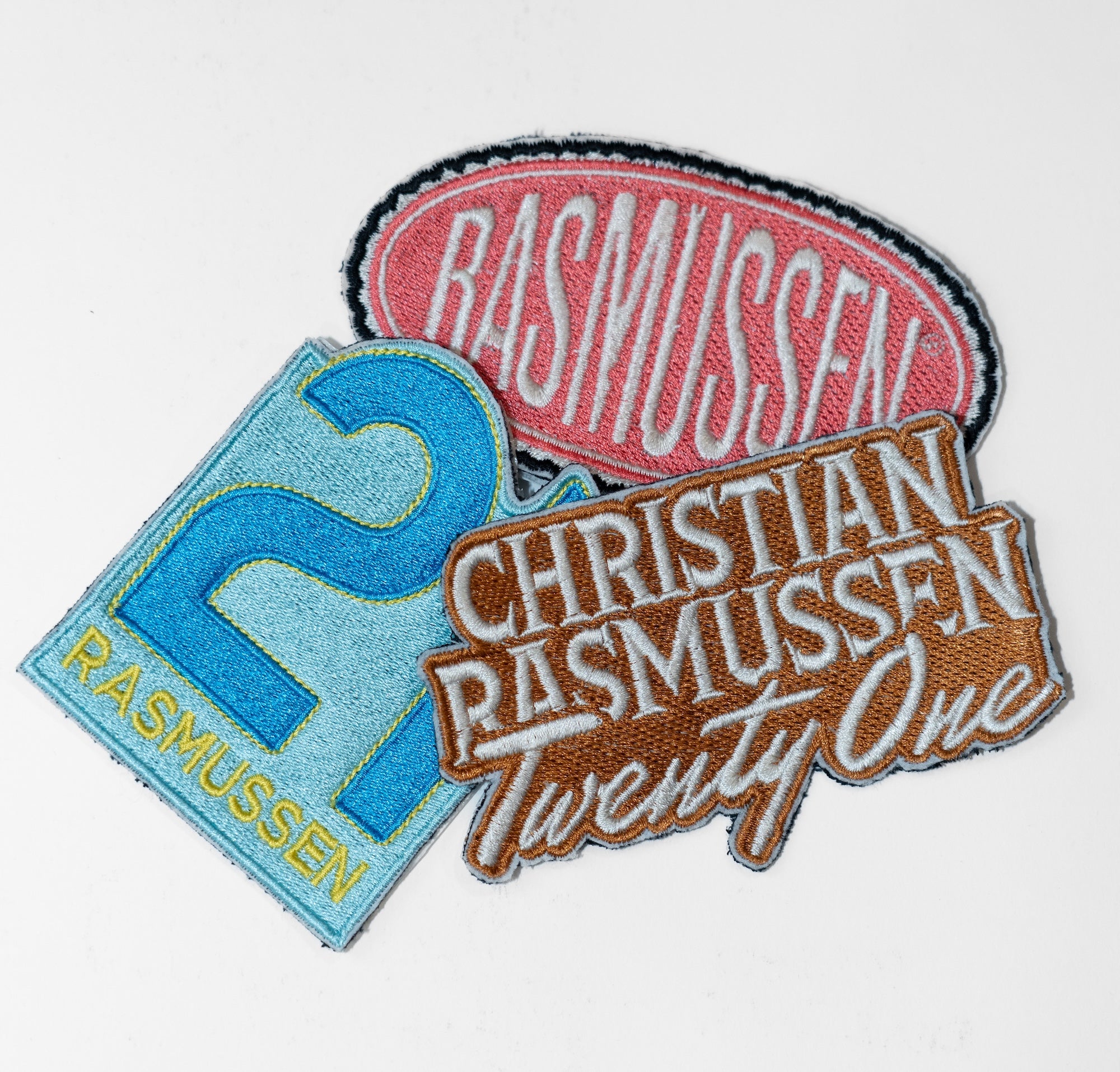 Three embroidered patches with text and numbers on a white background