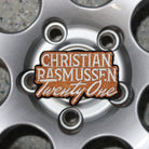 Close-up of a car wheel with a 'Christian Rasmussen Twenty One' badge.